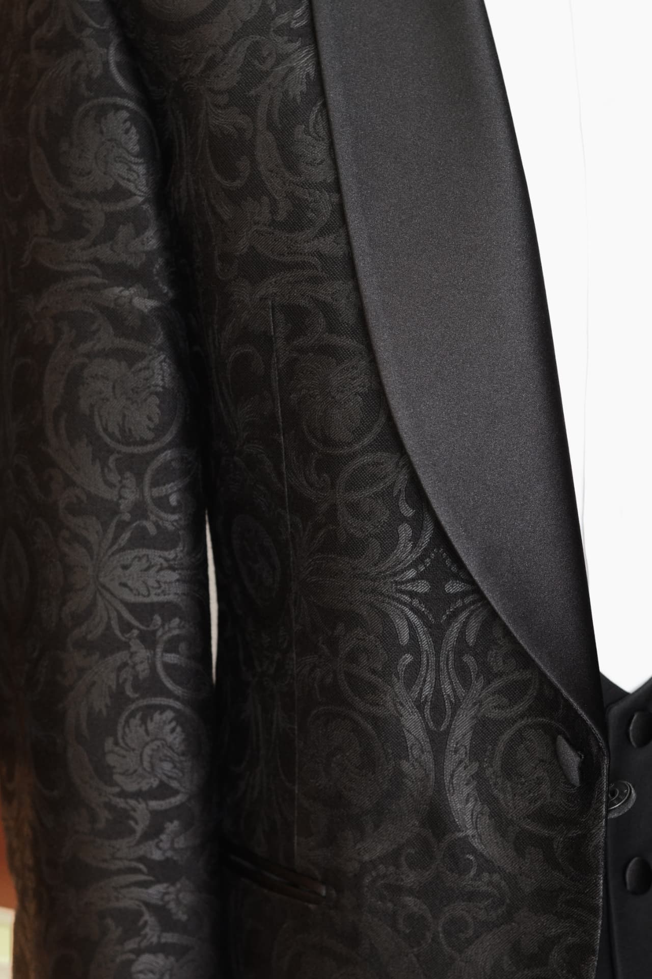 Detal czarnego smokingu z tkaniny jacquard Carnet - jedwabna klapa szalowa i wzór żakardowy